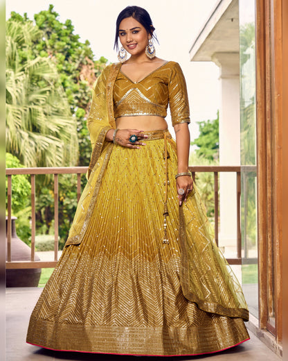 Woman wearing a mustard yellow traditional outfit standing on a balcony with greenery in the background