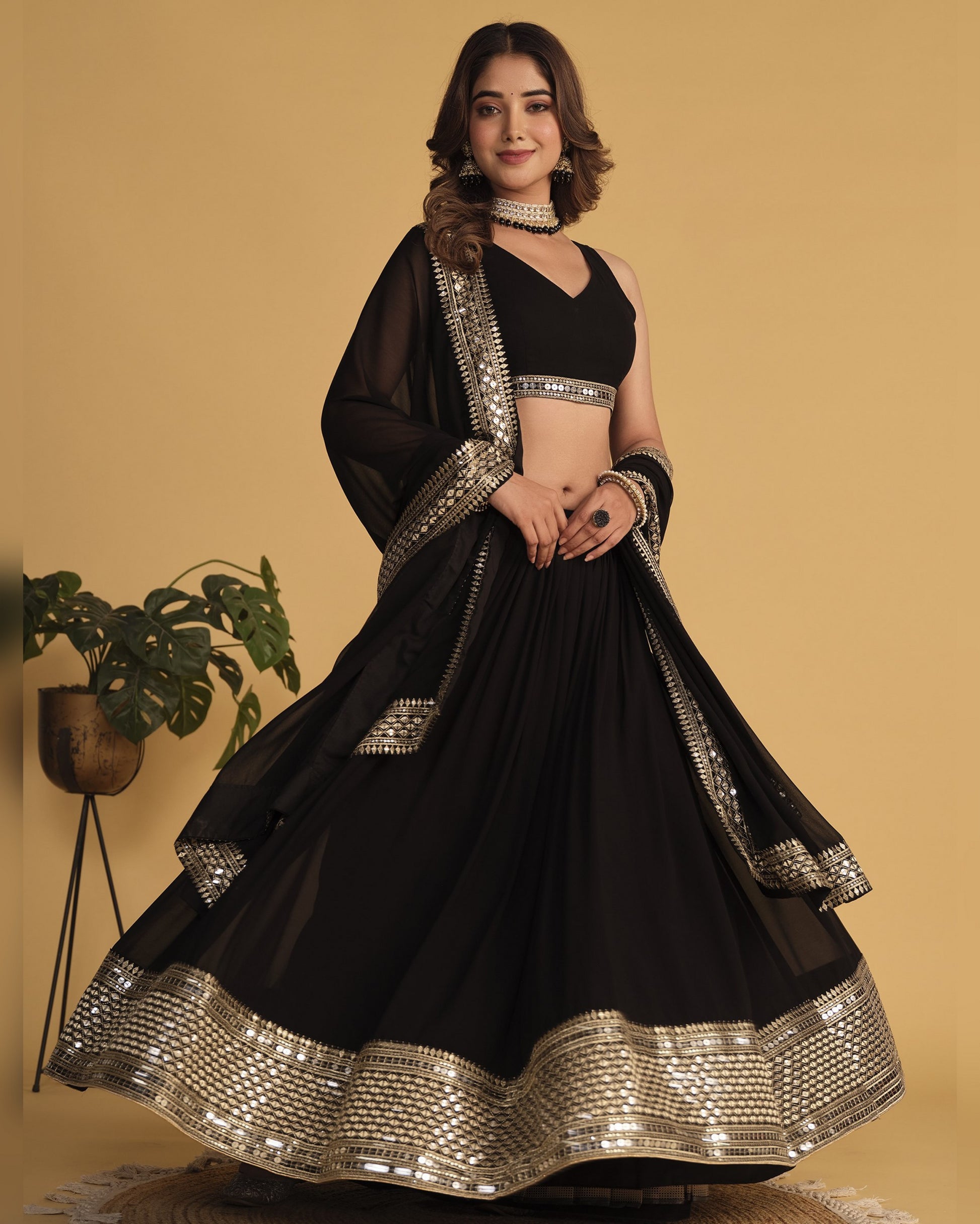 Woman wearing a black traditional outfit with gold embroidery on a beige background