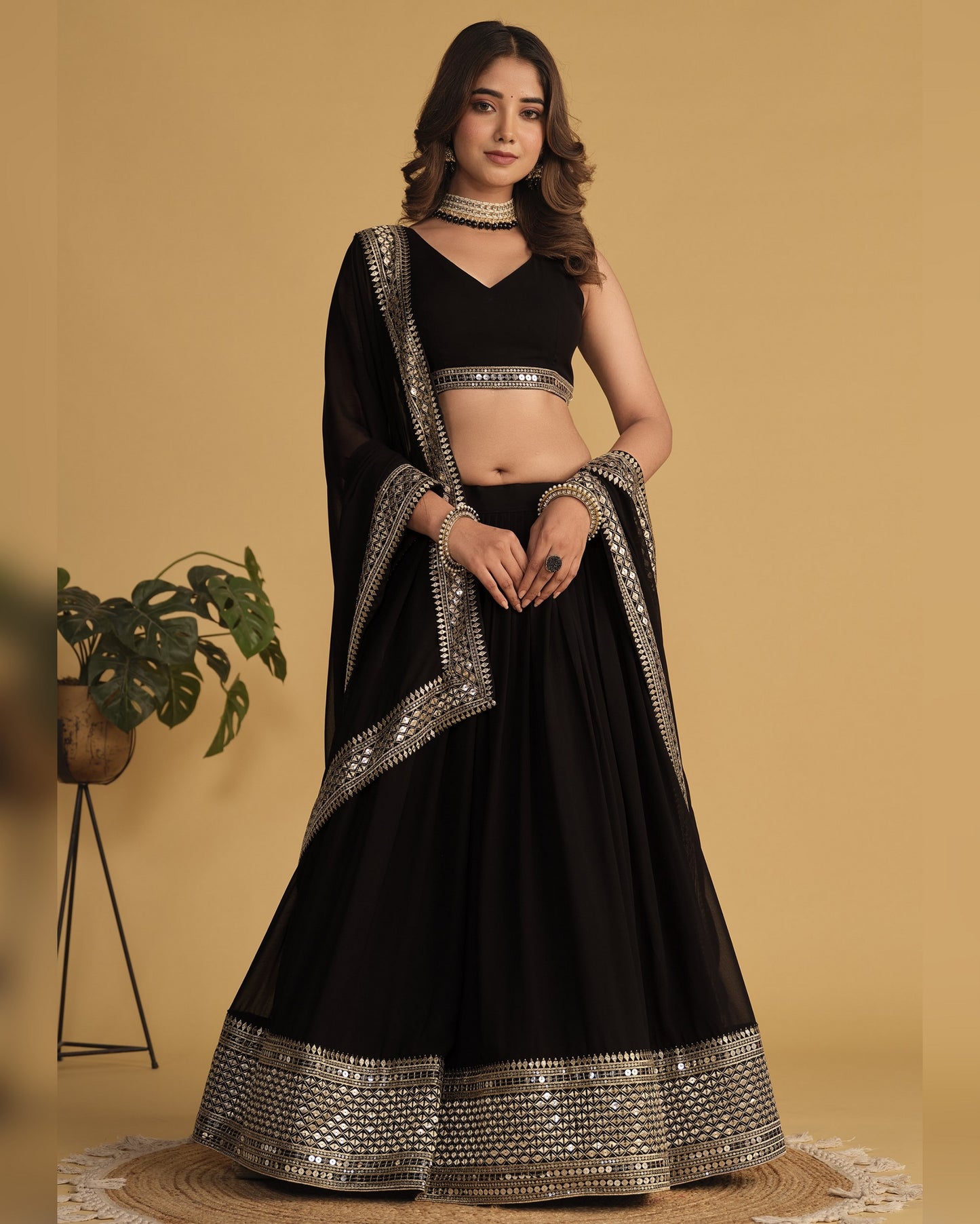 Woman wearing a black traditional outfit with silver details on a beige background