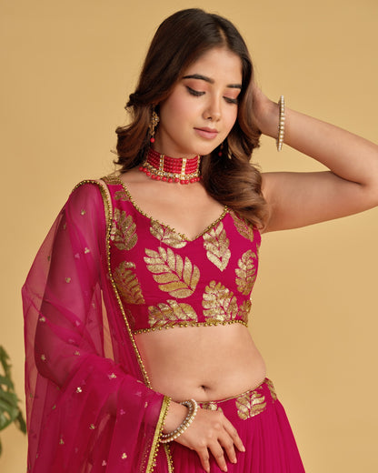 Woman wearing a pink and gold traditional outfit with a beige background