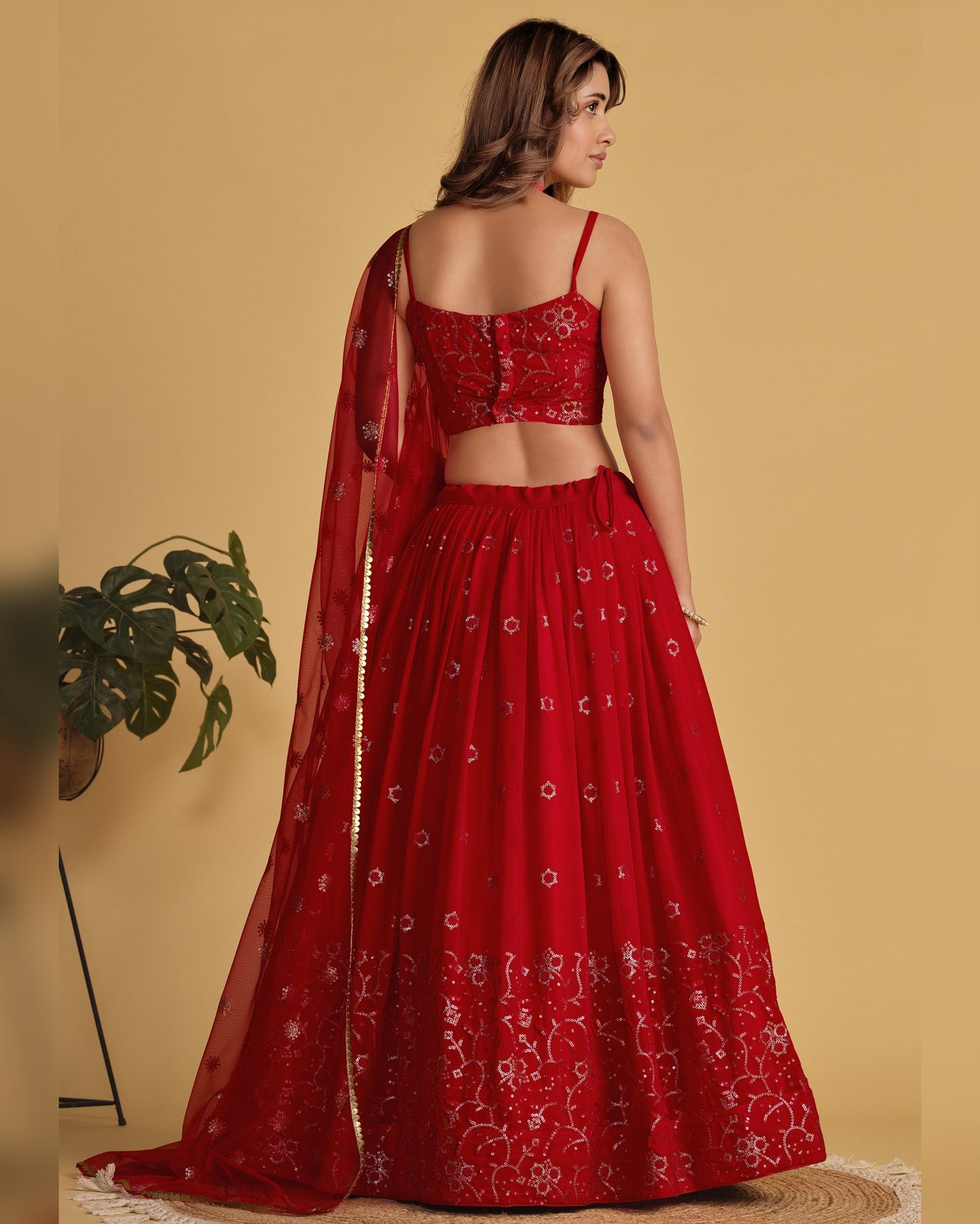 Red embroidered traditional outfit with a matching dupatta on a yellow background