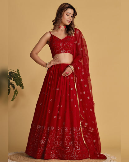 Red embroidered saree with a matching blouse on a beige background