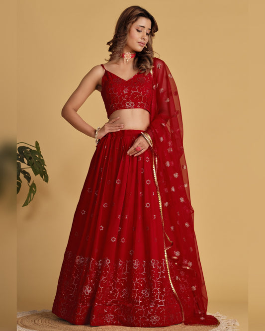 Red embroidered saree with a matching blouse on a beige background