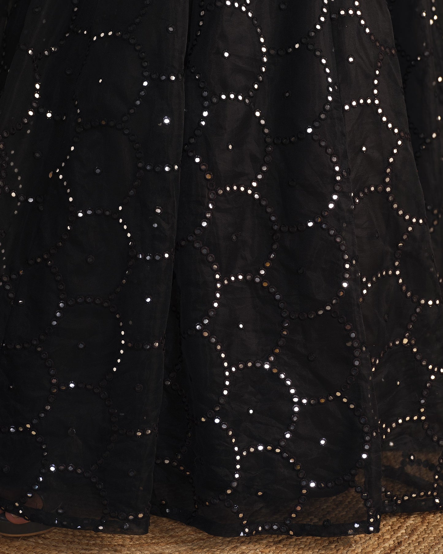 Black fabric with star patterns and sequins on a textured surface