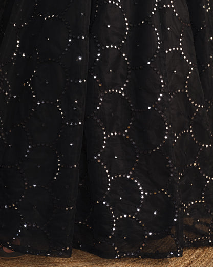 Black fabric with star patterns and sequins on a textured surface