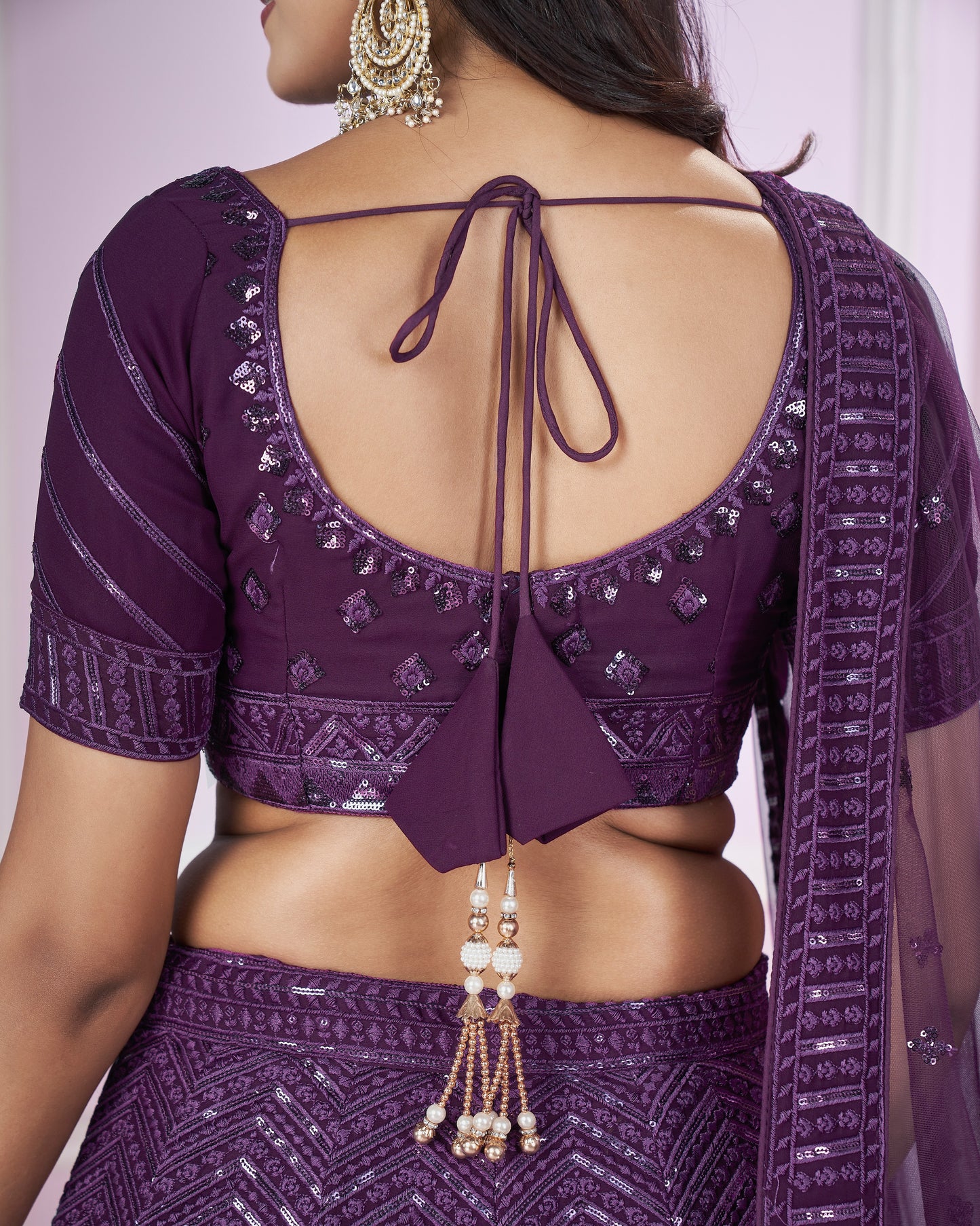 Purple traditional outfit with intricate designs and a backless top.