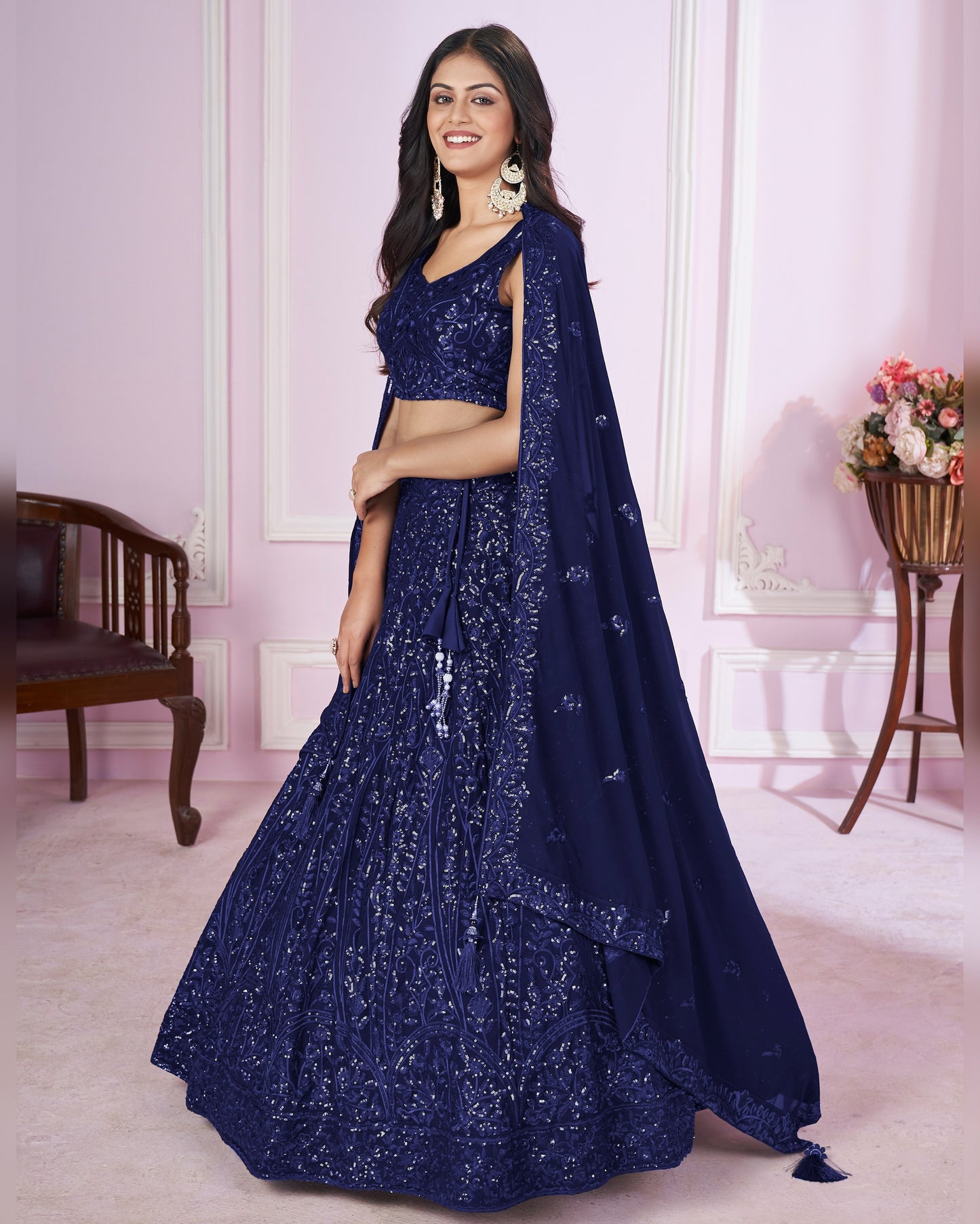 Woman wearing a blue embroidered lehenga in an indoor setting