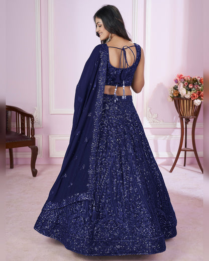Woman wearing a blue embroidered lehenga in an elegant room setting