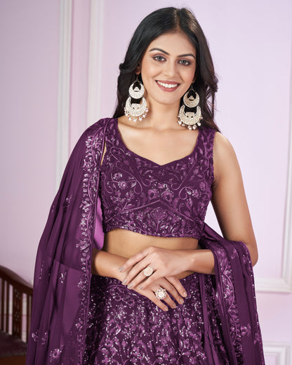 Woman wearing a purple traditional outfit with jewelry against a light background