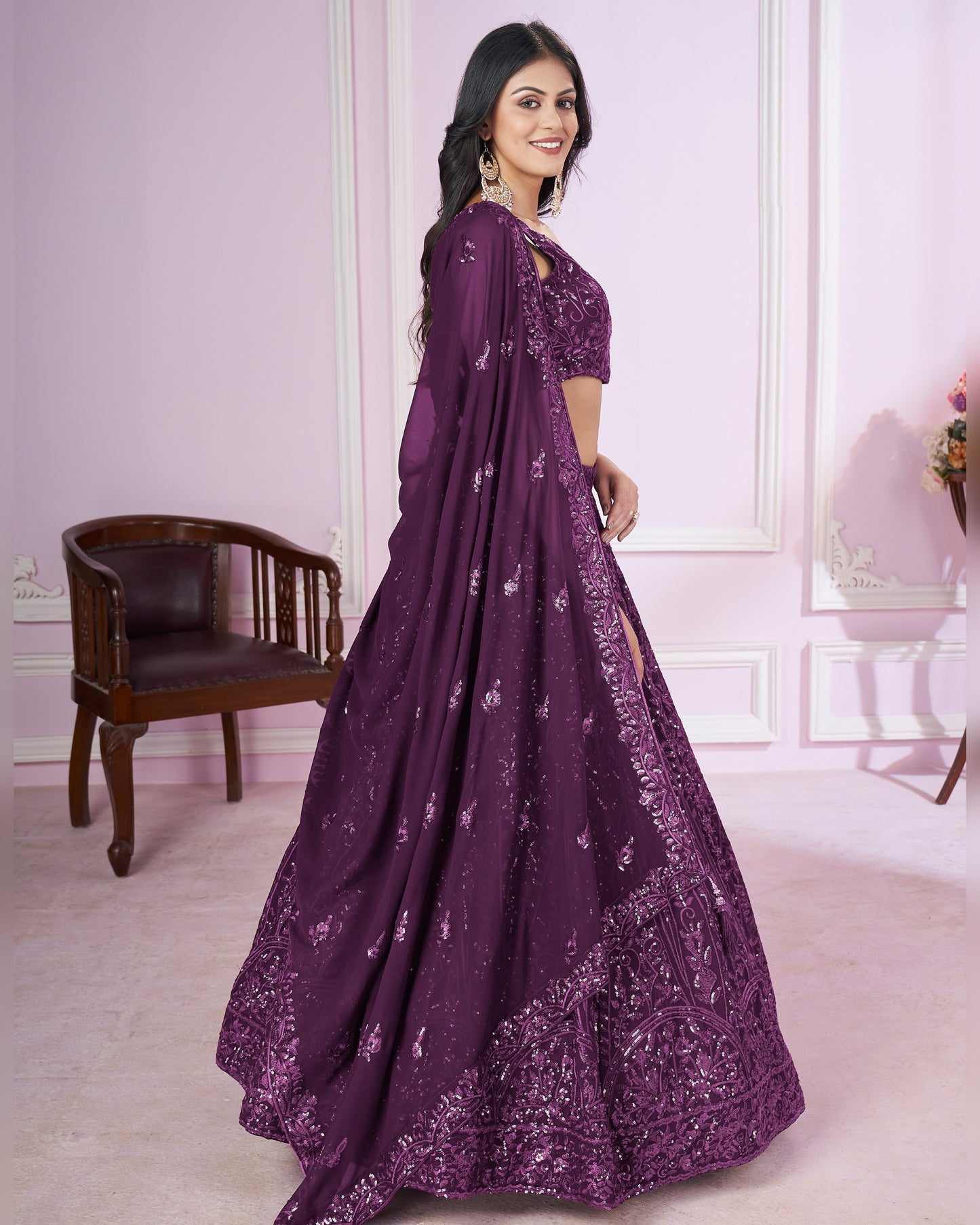 Woman wearing a purple embroidered dress in an elegant room.