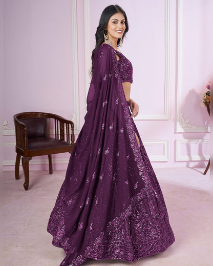 Woman wearing a purple embroidered dress in an elegant room.