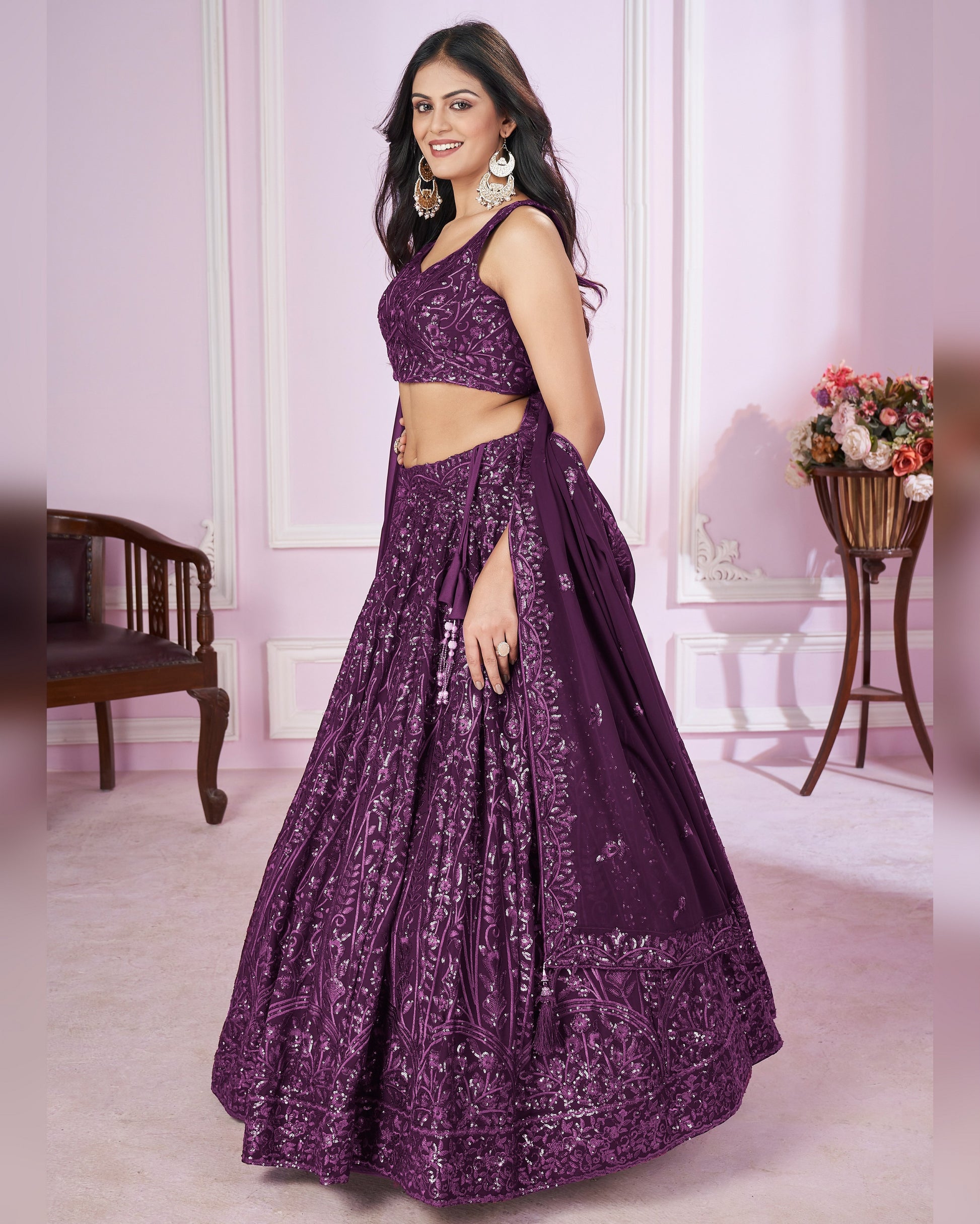 Woman wearing a purple embroidered lehenga in an indoor setting