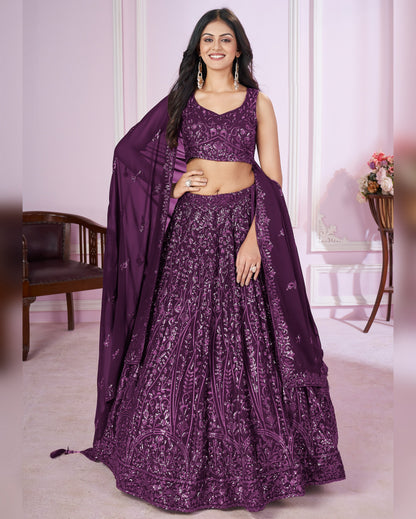 Woman wearing a purple embroidered lehenga with a matching dupatta in an indoor setting.