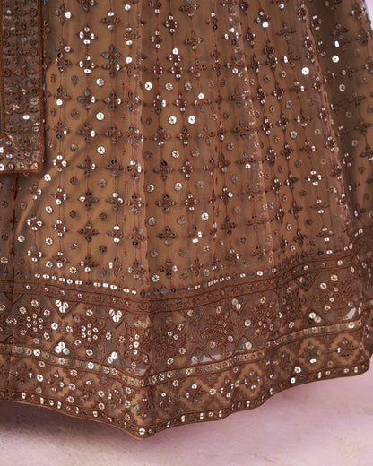 Close-up of a brown embroidered fabric with intricate patterns on a light background