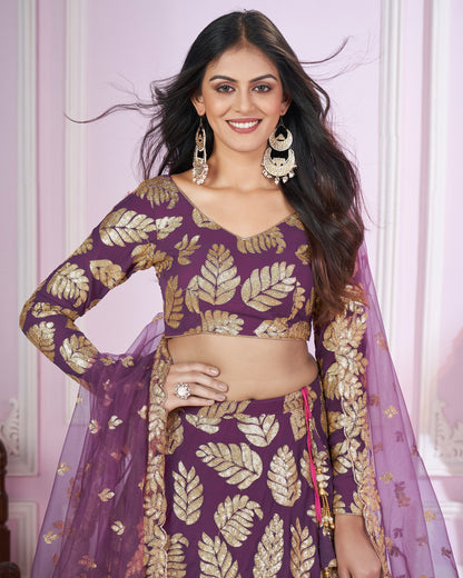 Woman wearing a purple and gold traditional outfit with a pink background