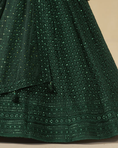 Close-up of a green embroidered fabric with a beige background