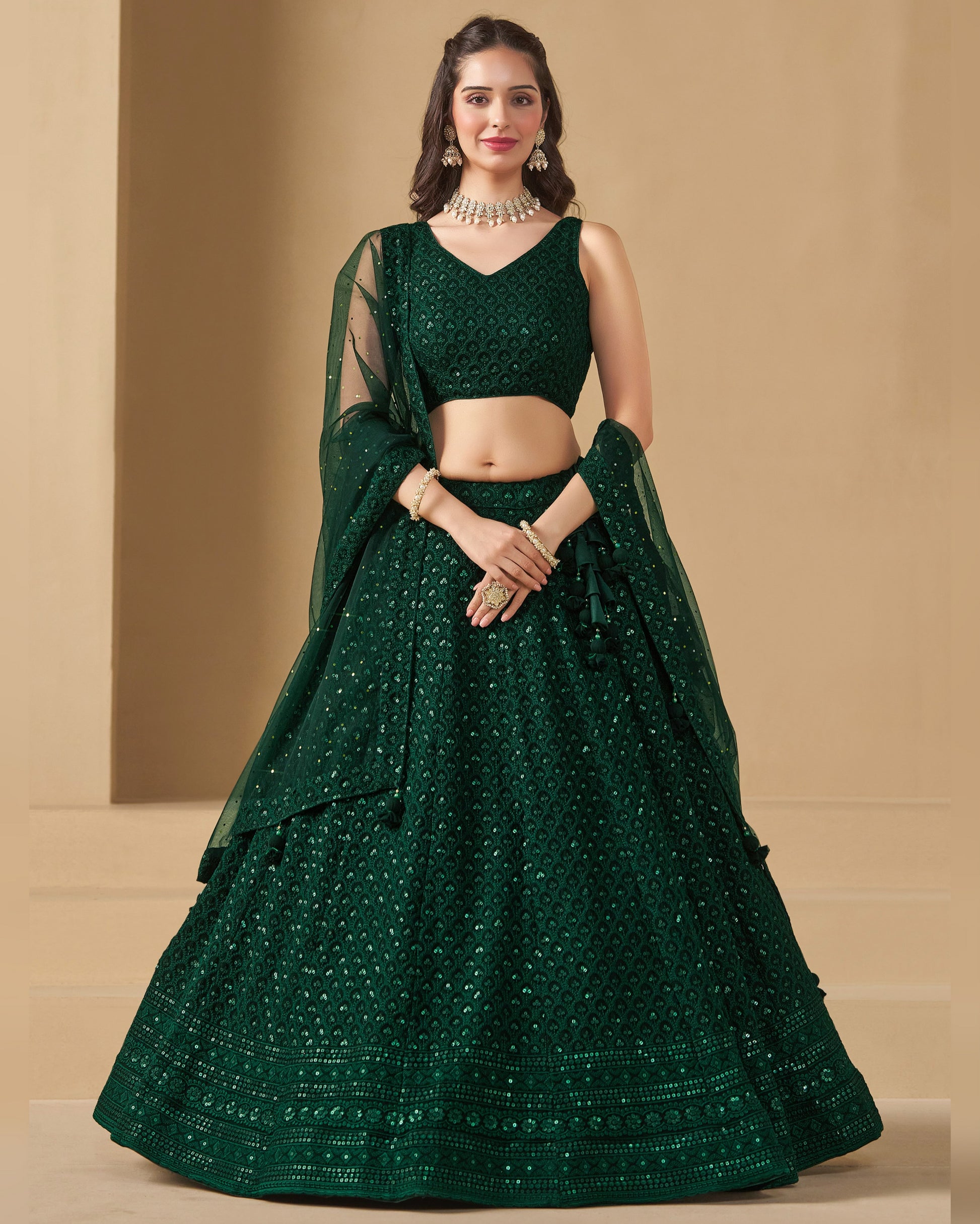 Woman wearing a green traditional outfit with a beige background