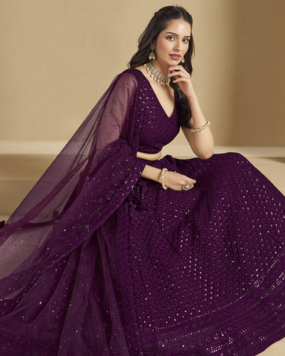 Woman wearing a purple saree with a beige background