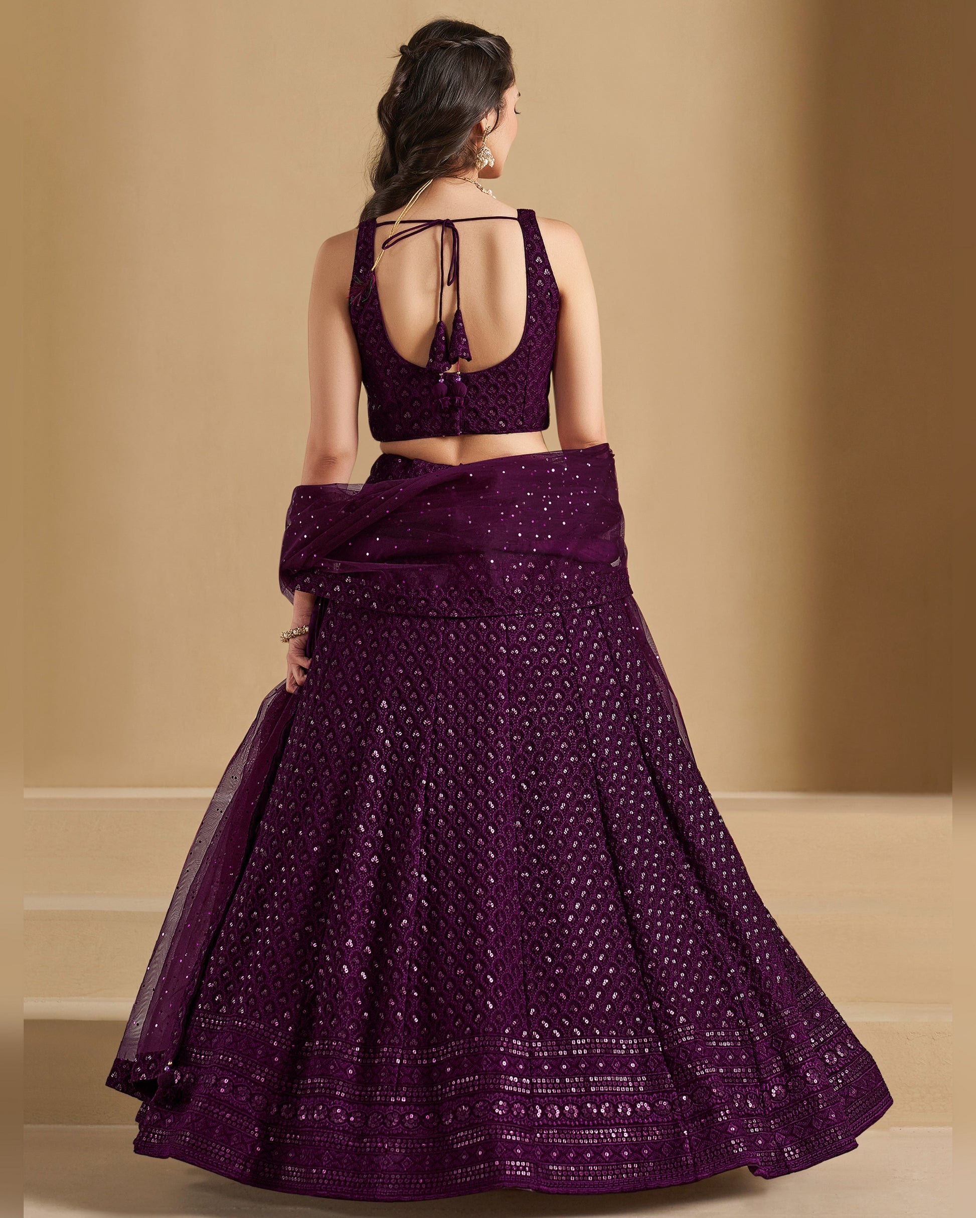 Woman wearing a purple traditional outfit with a beige background