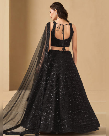 Black embroidered lehenga with sheer dupatta on a beige background