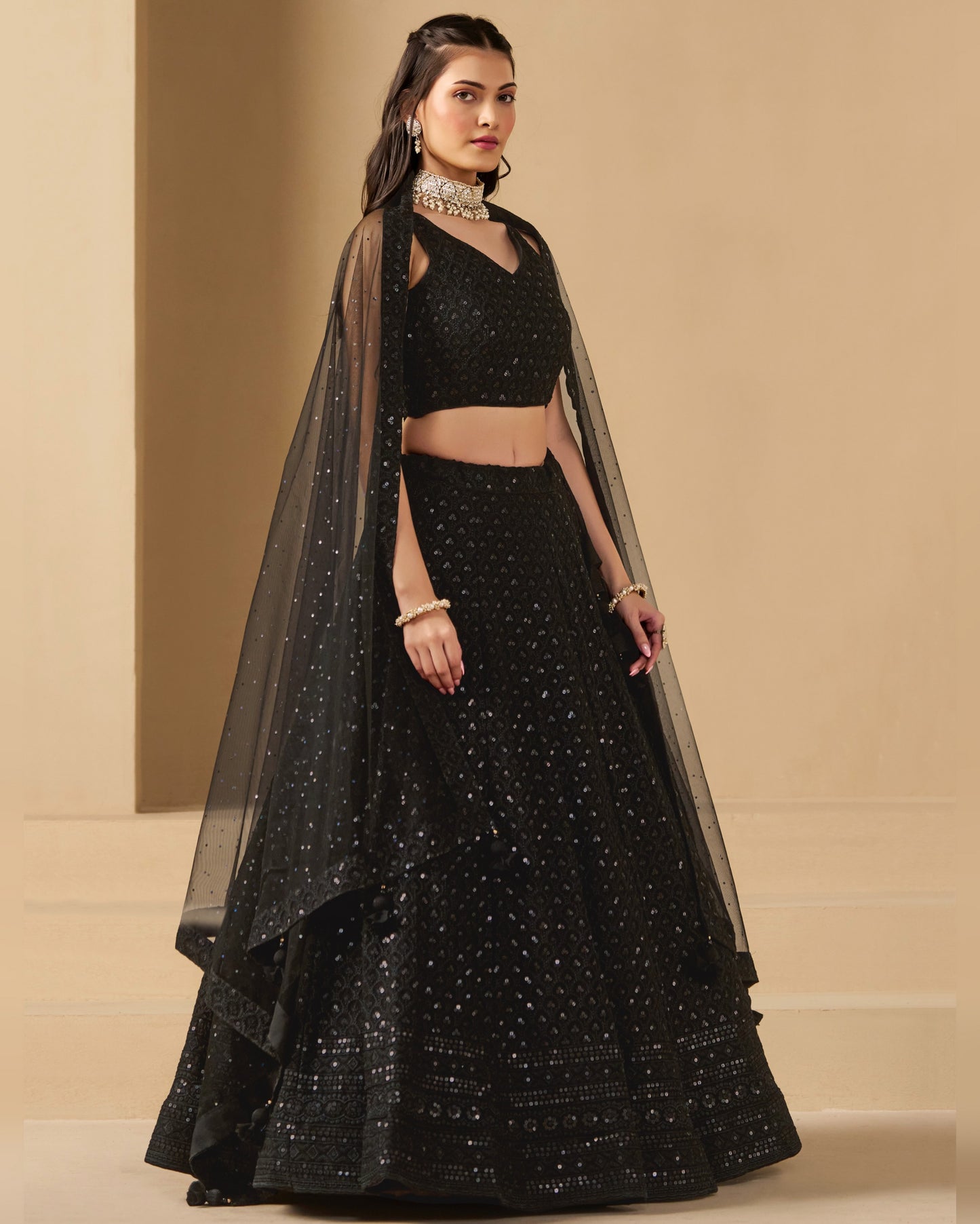 Woman wearing a black traditional outfit with a beige background