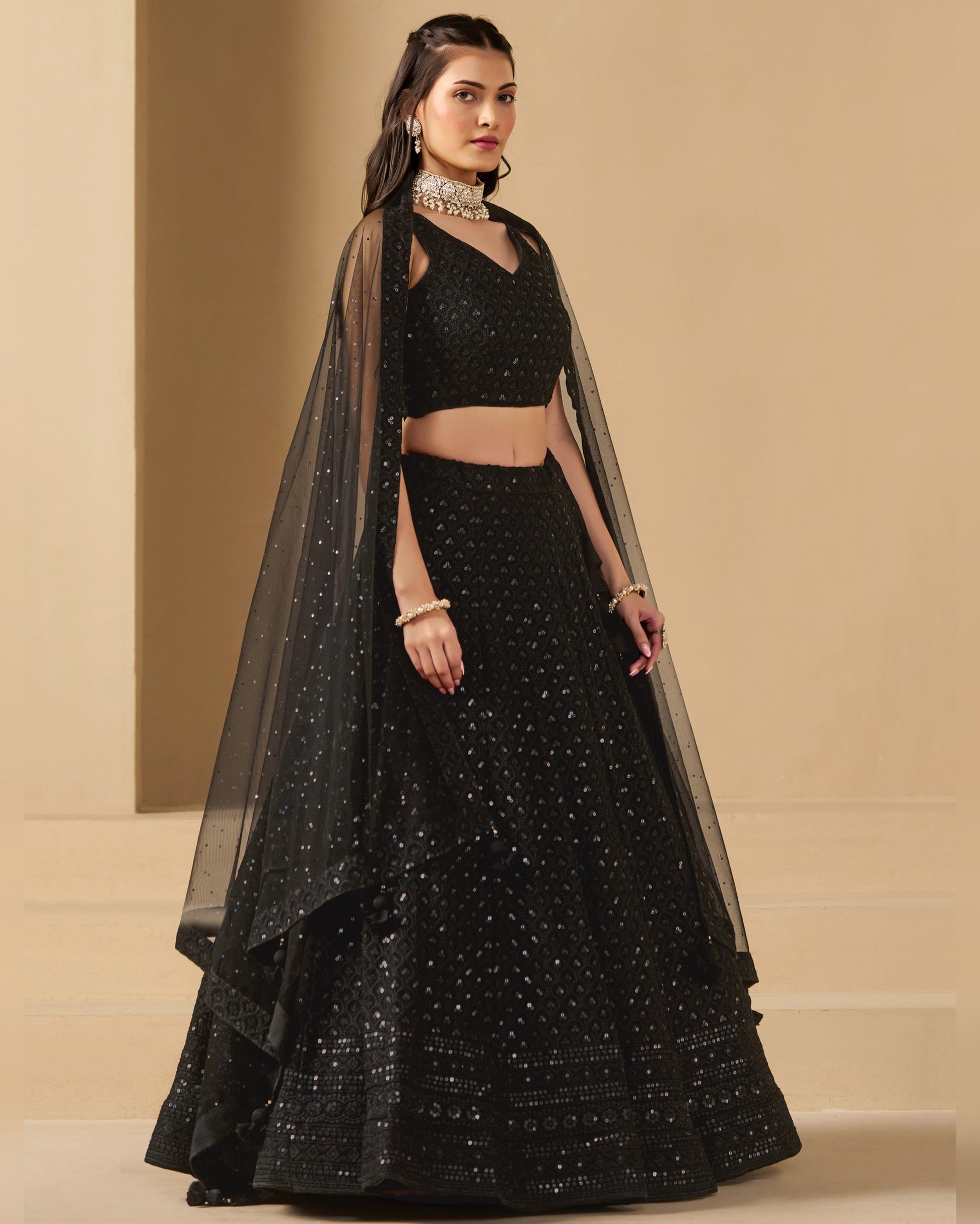 Woman wearing a black traditional outfit with a beige background