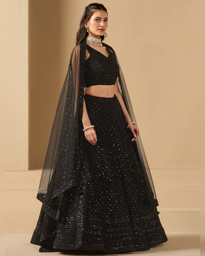 Woman wearing a black traditional outfit with a beige background