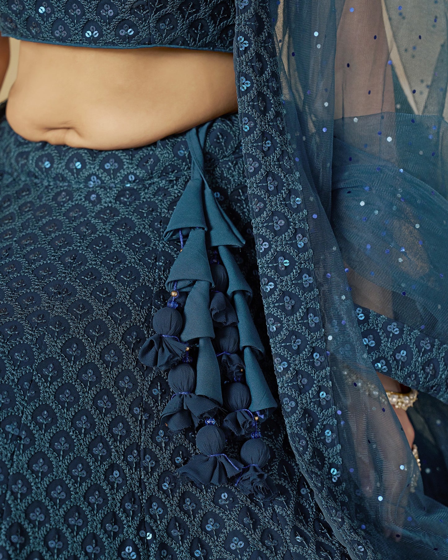 Close-up of a dark blue embroidered traditional outfit with a focus on the fabric details.