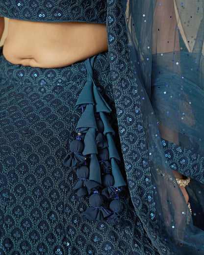Close-up of a dark blue embroidered traditional outfit with a focus on the fabric details.