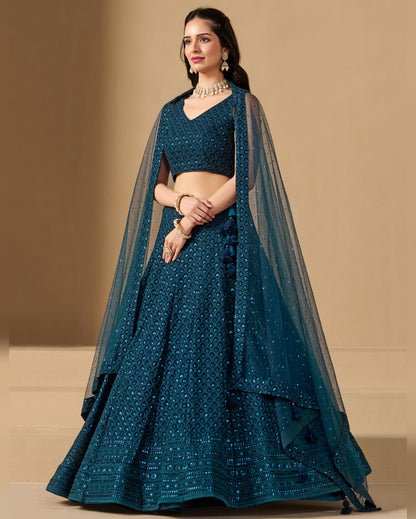 Teal traditional outfit with a matching dupatta on a beige background