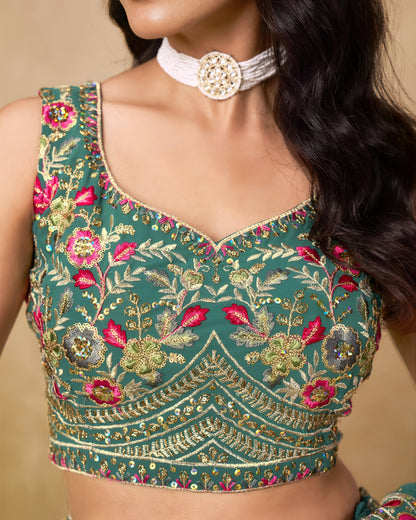 Green embroidered blouse with floral patterns on a beige background