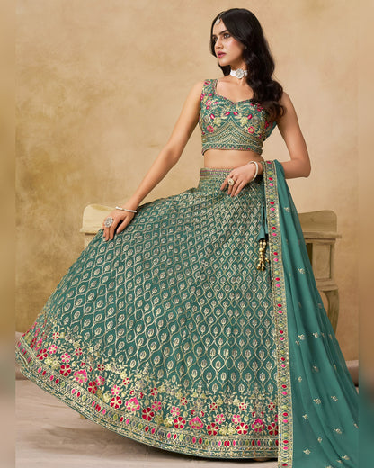 Woman wearing a green embroidered lehenga with a beige background