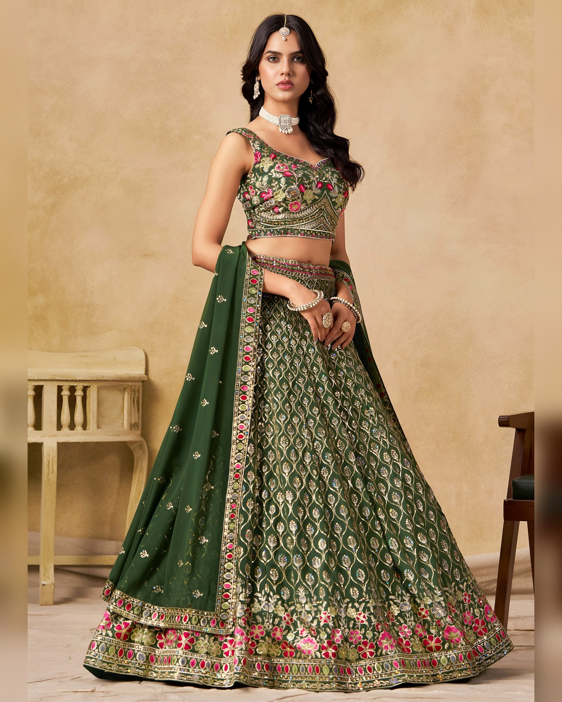 Woman wearing a green embroidered traditional outfit with a beige background