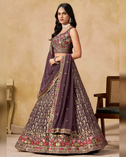 Woman wearing a traditional embroidered lehenga with a beige background