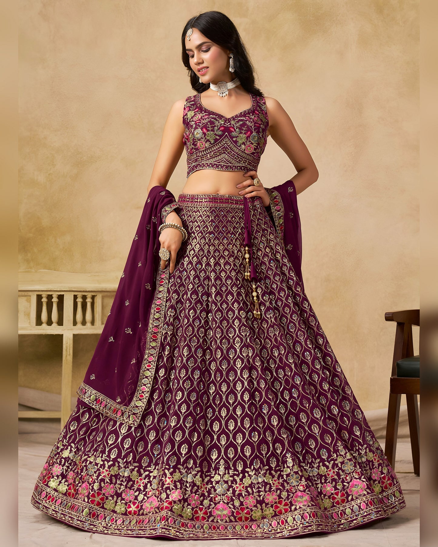 Woman wearing a traditional purple and gold embroidered lehenga with a matching dupatta.