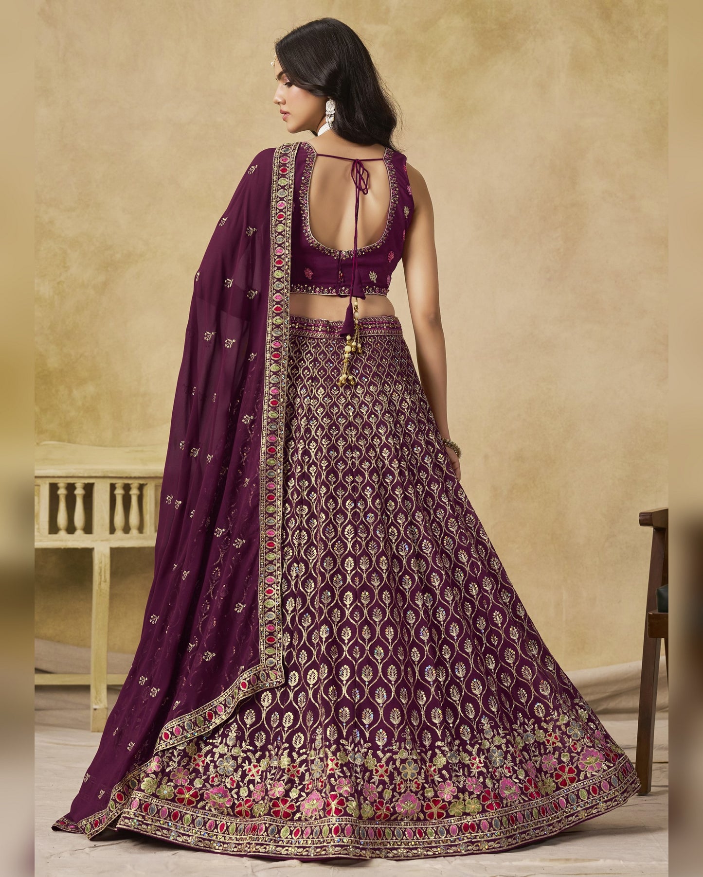 Woman wearing a purple embroidered traditional outfit with a beige background