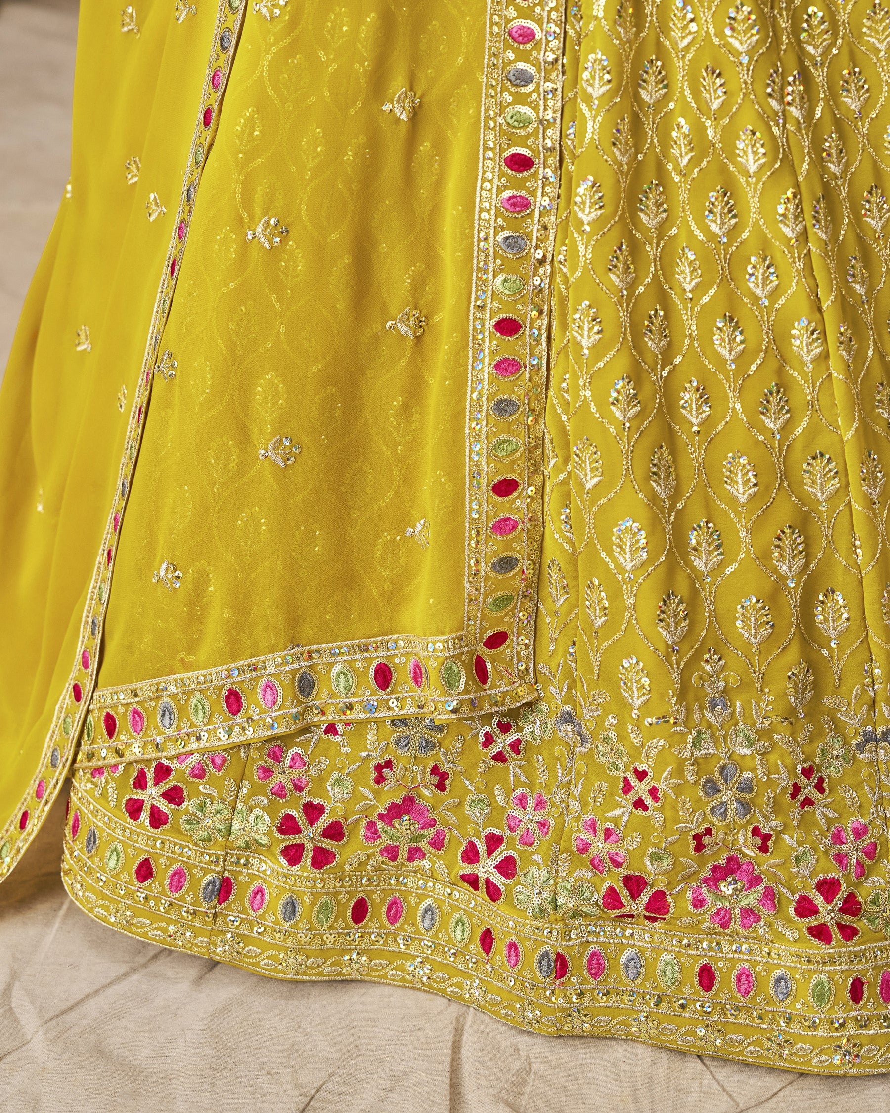 Yellow embroidered fabric with floral patterns on a neutral background