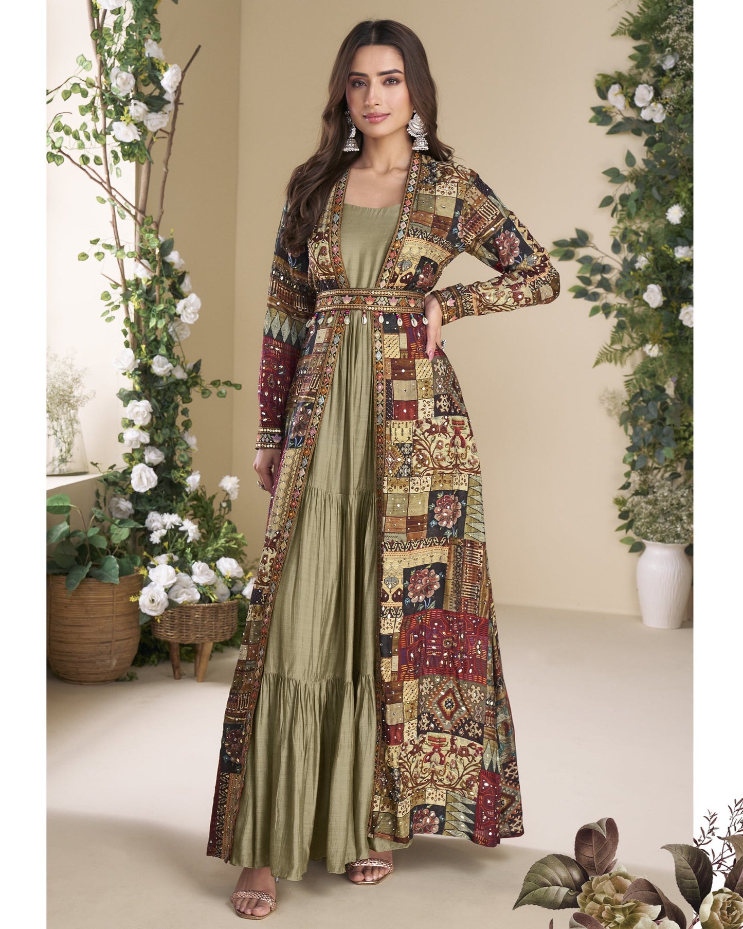 Woman wearing a long, patterned dress with a matching jacket in a decorated room.