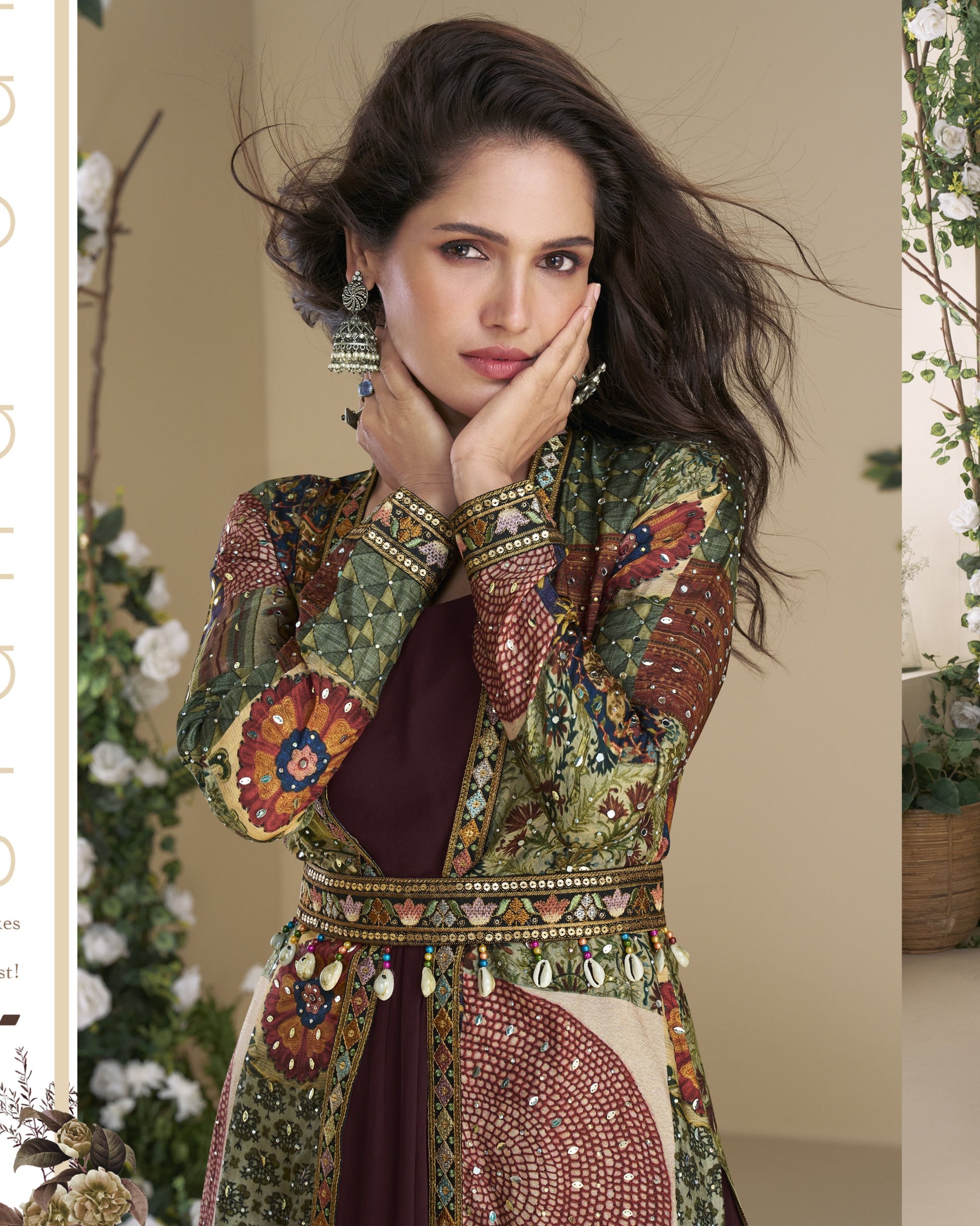 Woman wearing a traditional embroidered outfit with jewelry, standing against a neutral background.