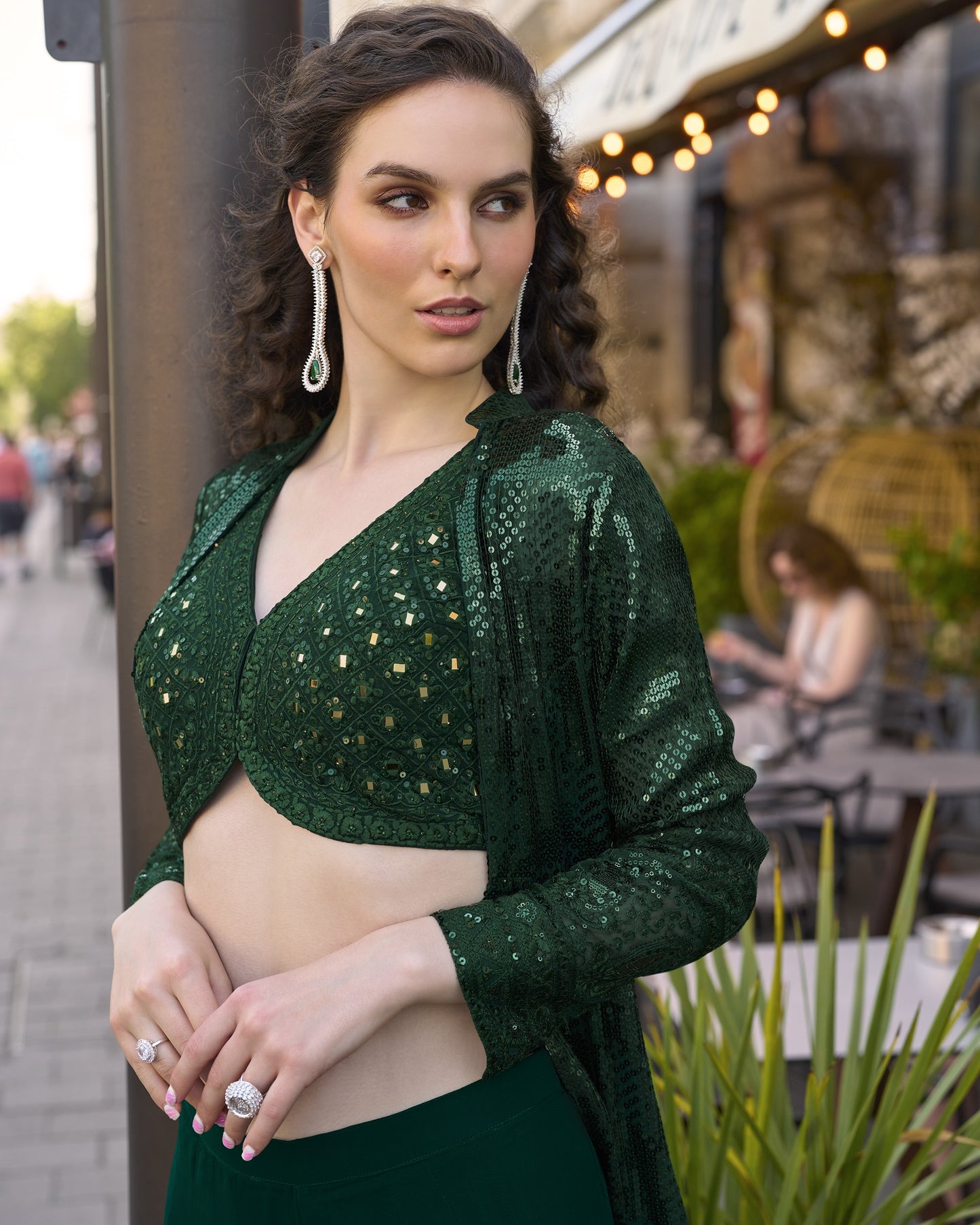Woman wearing a green sequined top in an outdoor setting