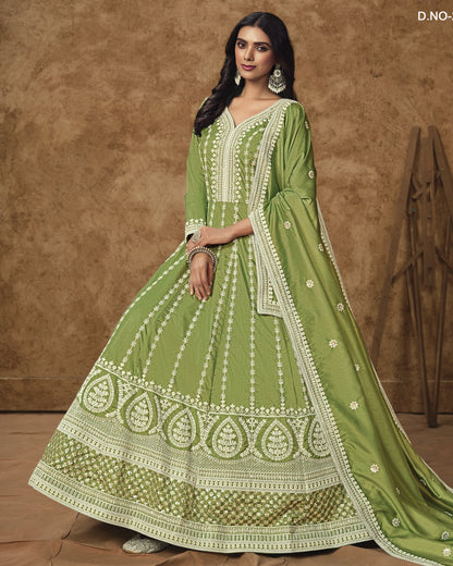 Woman wearing a green embroidered traditional outfit against a brown background