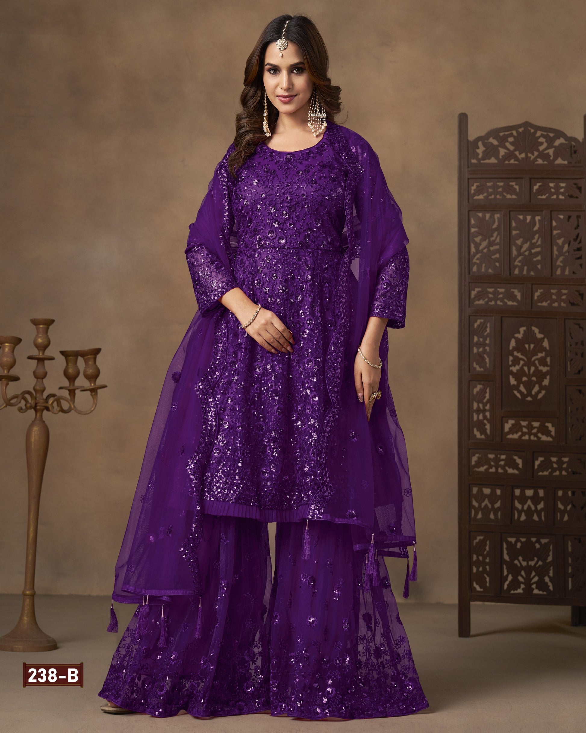 Woman wearing a purple embroidered traditional outfit with a brown background