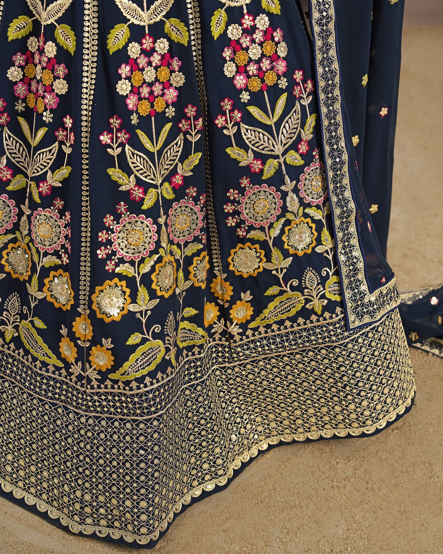 Navy blue fabric with intricate floral embroidery on a beige background
