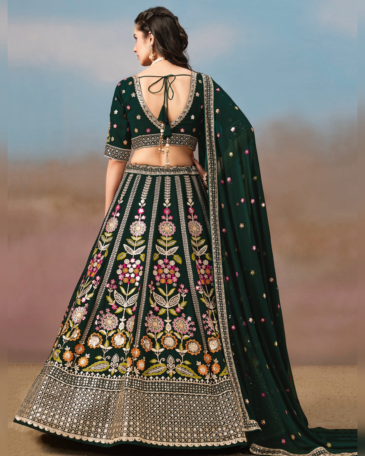 Woman wearing a dark green embroidered lehenga with a blurred background