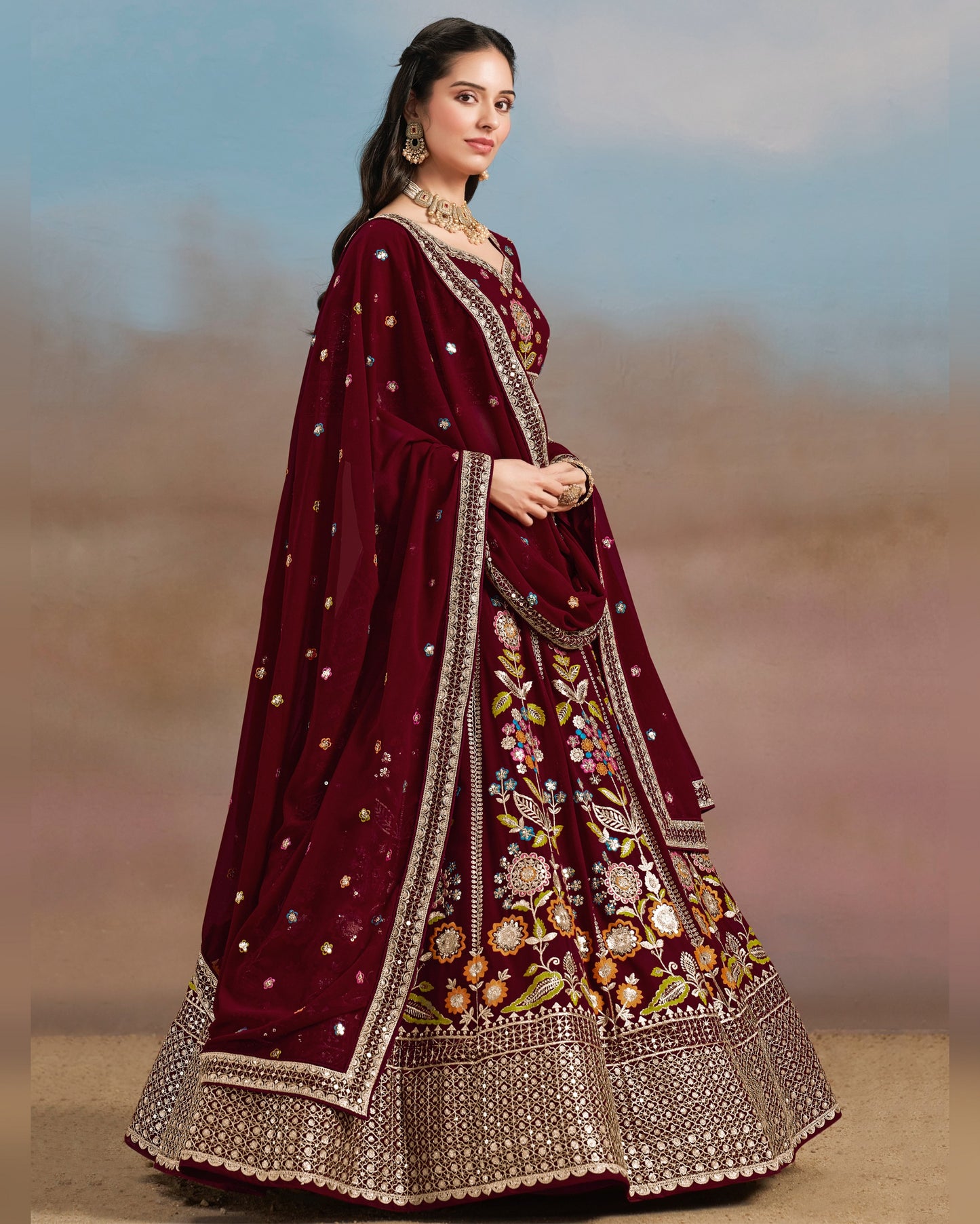Woman wearing a maroon embroidered traditional outfit with a blurred background