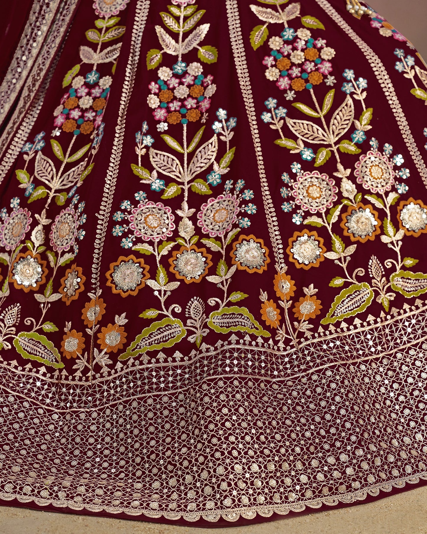 Close-up of a maroon fabric with intricate floral embroidery