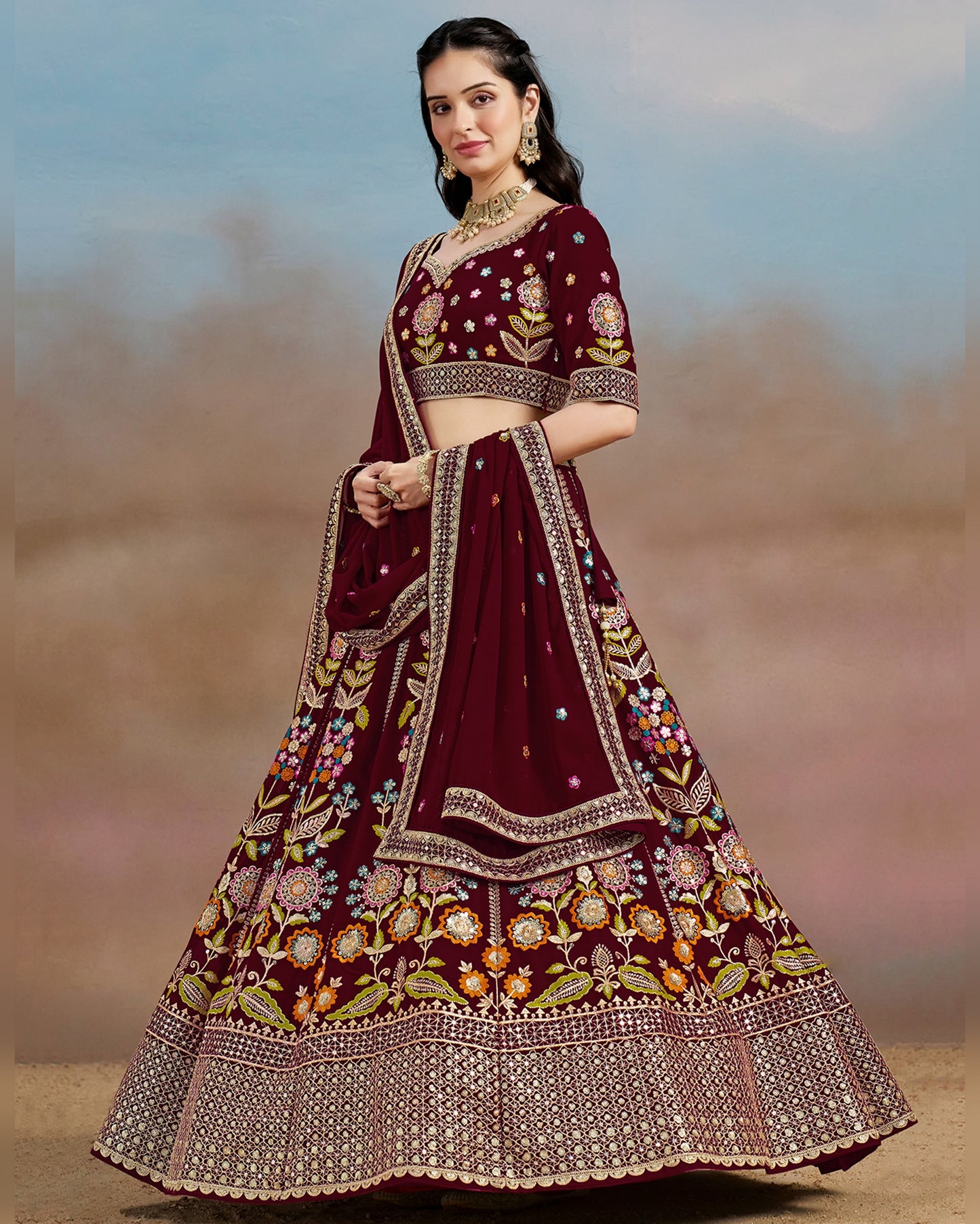 Woman wearing a maroon embroidered traditional outfit with a blurred natural background