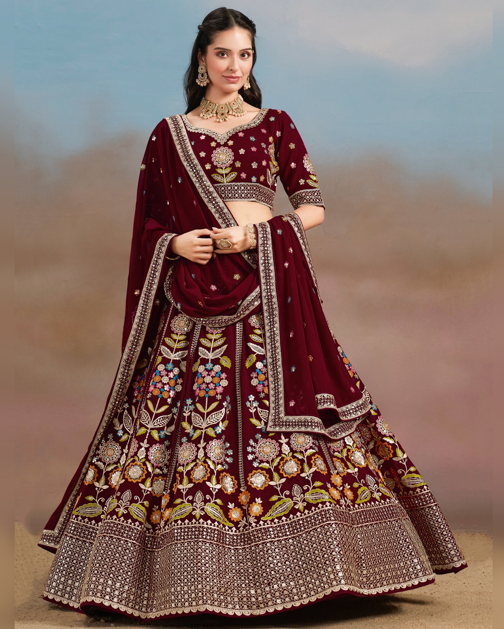 Woman wearing a maroon embroidered traditional outfit with a blurred background