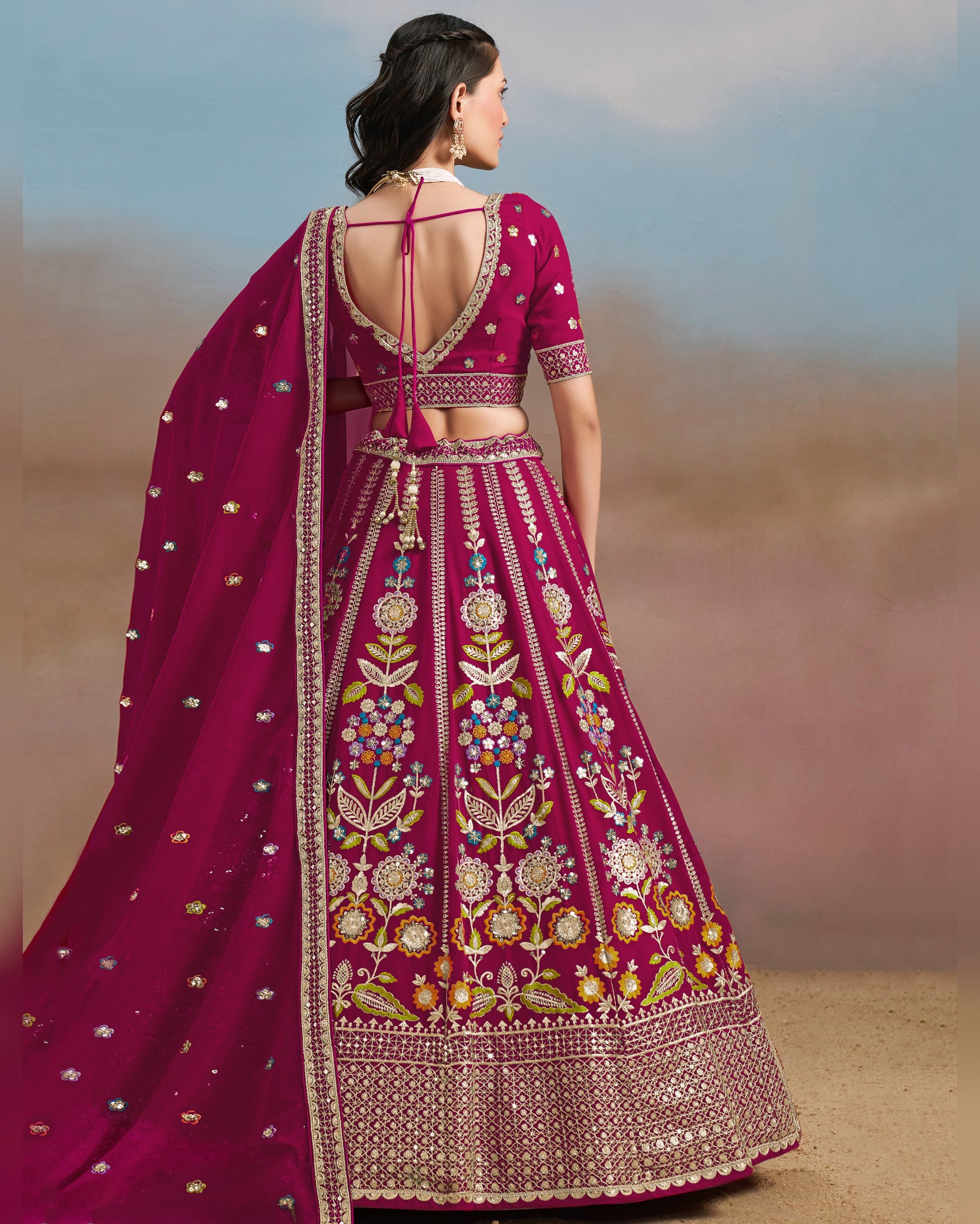 Woman wearing a traditional embroidered pink lehenga with a blurred background