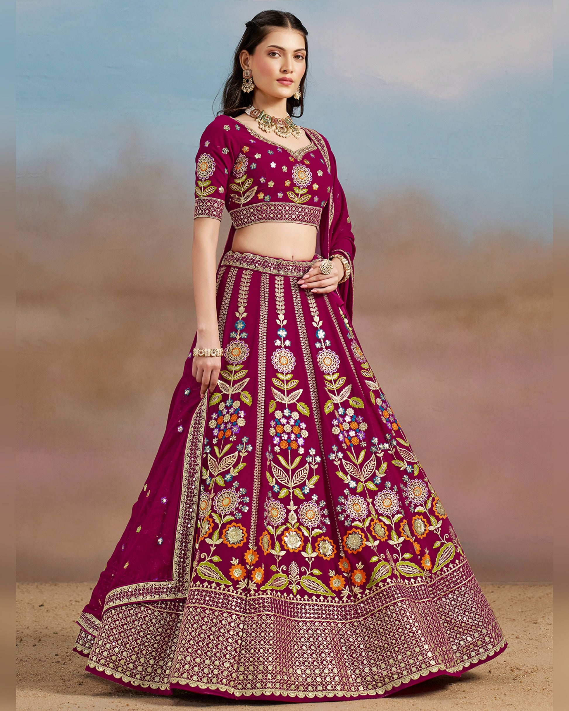 Woman wearing a traditional embroidered pink lehenga with a blurred background